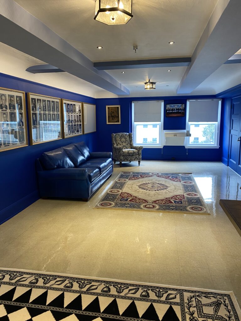 Bright blue room with a leather sofa and patterned chair