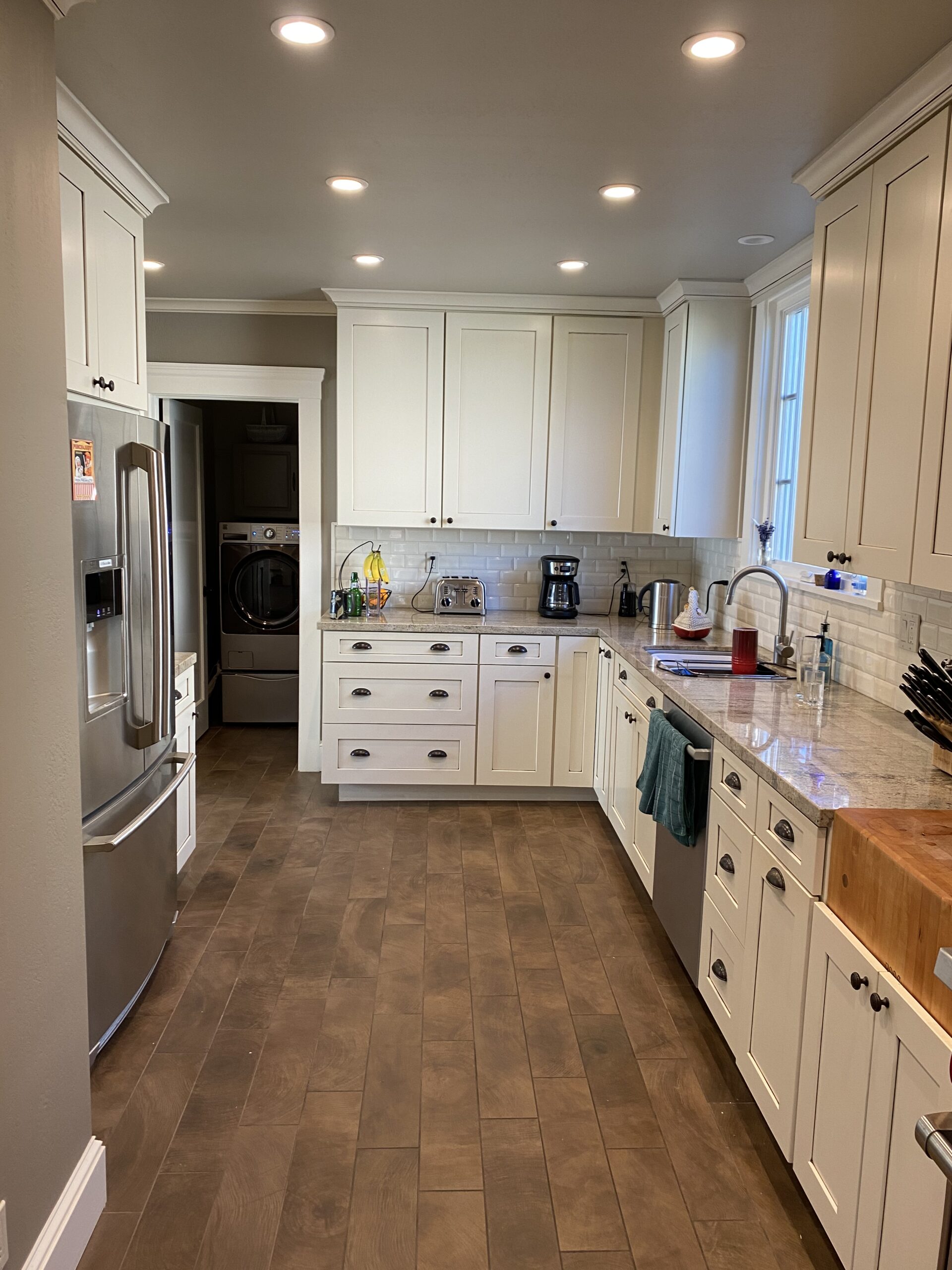 Bright, modern kitchen featuring white cabinetry, granite countertops, and stainless steel appliances, ideal for cooking and entertaining.