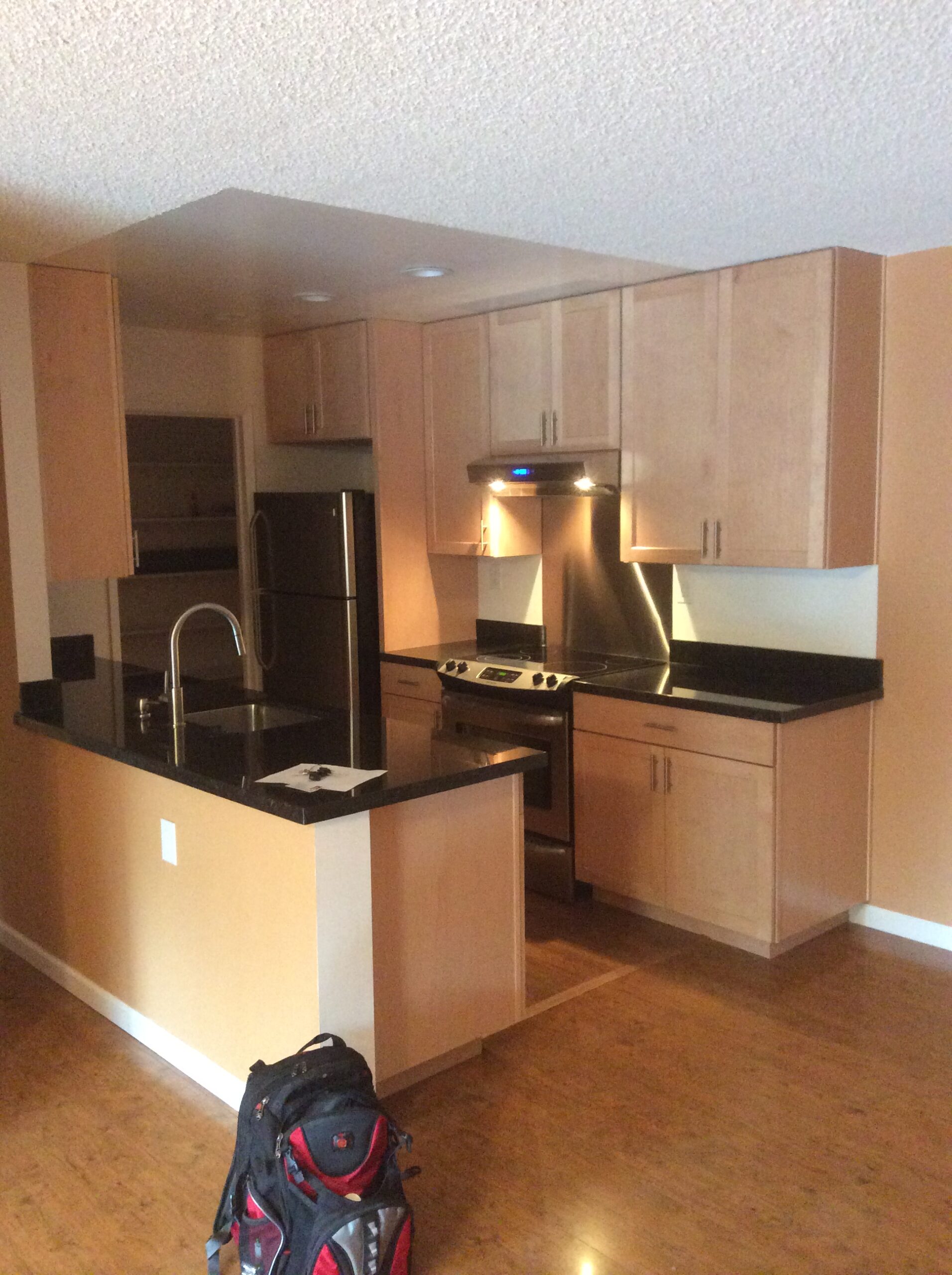 Modern kitchen remodeling in San Mateo County, CA, showcasing light wood cabinets and black countertops