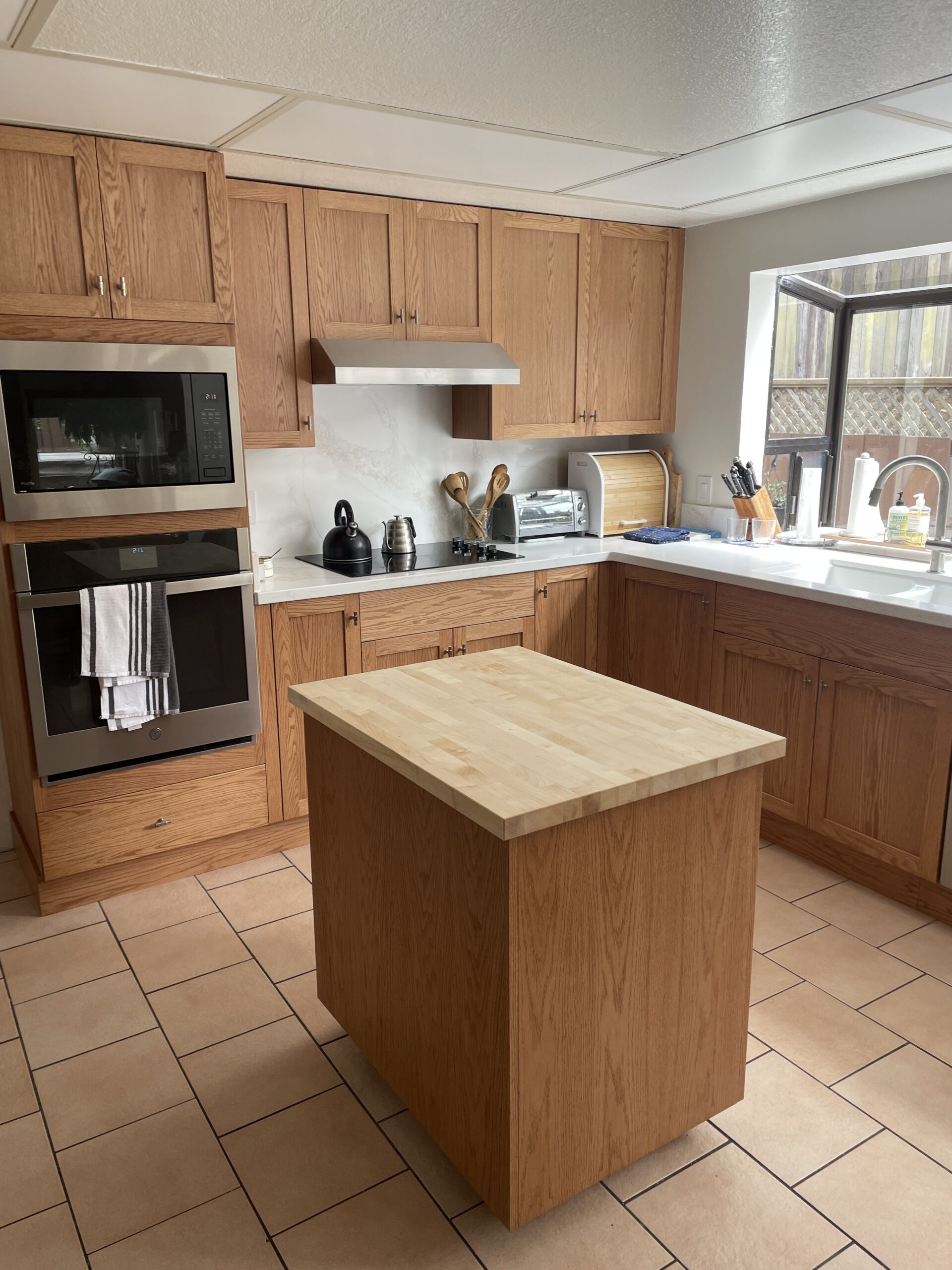 Kitchen remodeling in San Mateo County, CA, featuring oak cabinetry and a central island