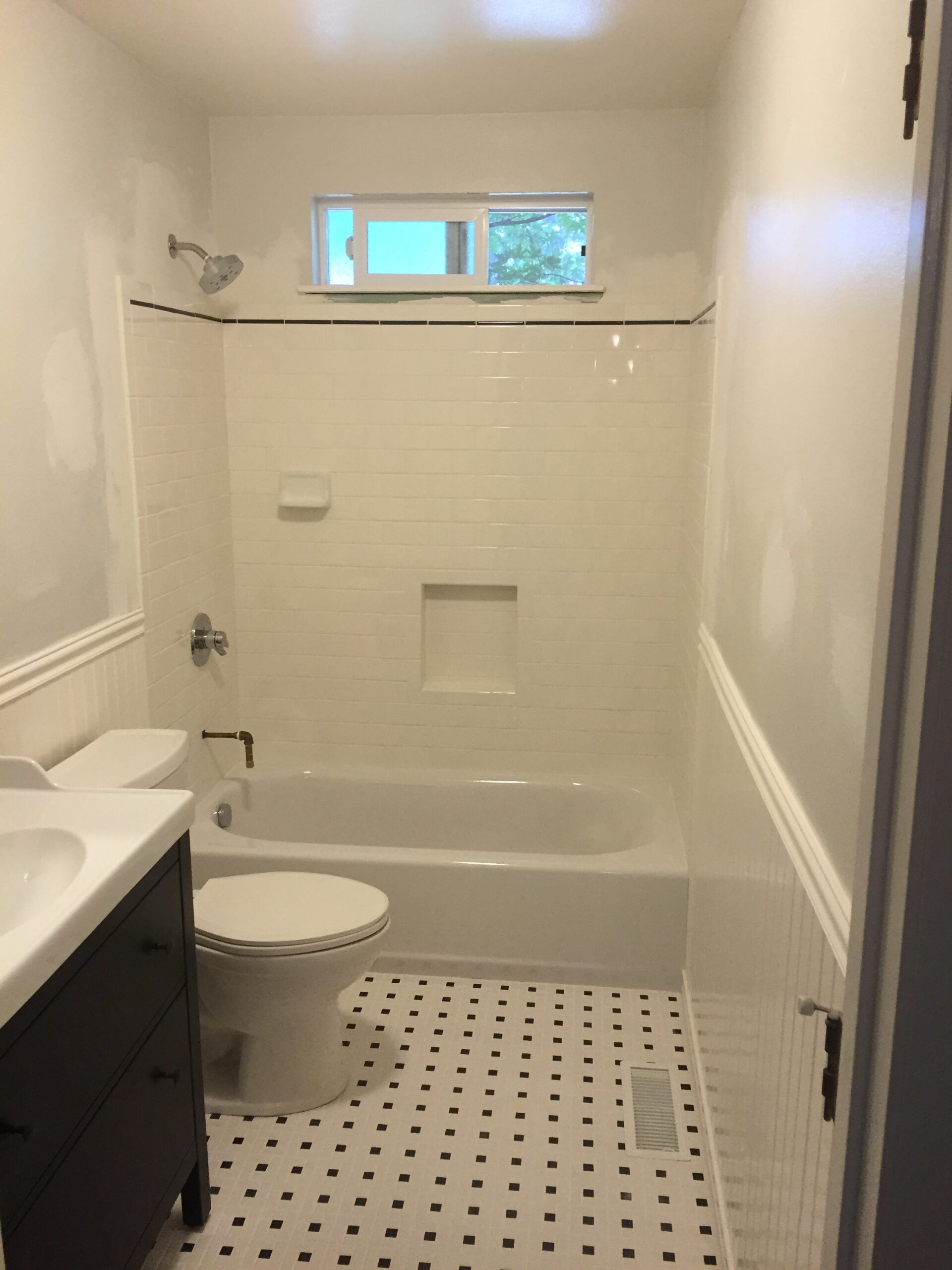 Bathroom remodeling in San Mateo County, CA, featuring white tile walls, bathtub, and a modern vanity